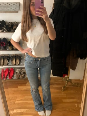 Ljusblå bootcut jeans - Säljer ett par ljusblå jeans med bootcut-modell och låg midja. Jeansen har klassisk femficksdesign, lätt slitning vid knät och är tillverkade i jeansmaterial. Perfekta för dig som gillar en avslappnad och trendig look. De är väldigt classy och sitter väldigt fint på! Knappast använt heller. 💕