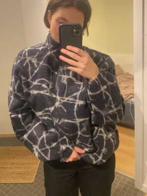 Svart fleece half zip från BDG - Mysig svart fleece-tröja från BDG Urban Outfitters med vitt tag tråds mönster. Tröjan har half zip, hög krage och lång ärm. Perfekt för kyliga dagar och riktigt skön att ha på sig. Relaxed/ loose fit.