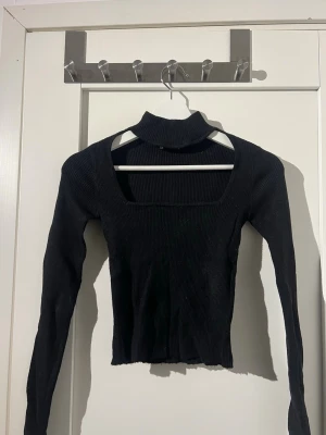Svart ribbad polotopp med fyrkantig urringning  - Säljer en svart ribbad croppad polotopp med lång ärm och fyrkantig urringning. Använd några få gånger och är från Zara