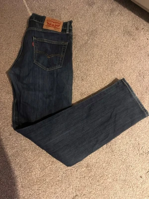 Levi's 504 mörkblå jeans W30 L32 - Säljer ett par Levi's 504 jeans i mörkblå tvätt med klassisk femficksdesign och kontrastsömmar. Jeansen har rak passform och är tillverkade i slitstarkt bomullsjeansmaterial. Perfekt för dig som gillar tidlös stil och vill ha ett par schyssta jeans.