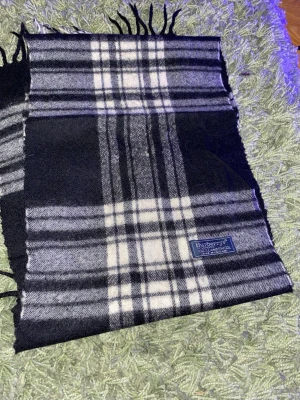 Burberry scarf - Vintage äkta Burberry-scarf i klassiskt rutmönster. Tillverkad i högkvalitativt, mjukt material som ger en lyxig och tidlös känsla. En ikonisk Burberry-accessoar som passar perfekt till både vardag och finare tillfällen.  📦 Snabb frakt 💯 Äkthet garanteras ✨ Redo att användas direkt 