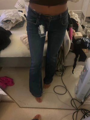 Blå bootcut jeans från Subdued - Säljer ett par snygga blå jeans från Subdued med bootcut passform och klassisk femficksdesign. Jeansen har en mörk tvätt och är tillverkade i jeansmaterial med en skön lowwaist. Perfekt för dig som gillar jeans med detaljer. Nya med lapp och passar mig som har S