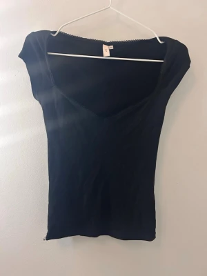 Svart v-ringad topp från Nelly - Säljer en svart topp från Nelly i storlek XXS❤️