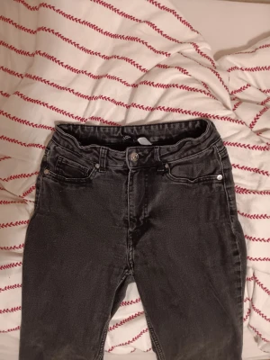 Svarta raka/flared jeans från Divided H&M - Säljer ett par svarta jeans från Divided H&M i storlek 36. Inte så säker, men jag skulle säga att de är raka men också lite flared. Klassisk femficksmodell med dragkedjegylf och knapp. Jeansen är tillverkade i stretchig bomullsdenim för extra komfort. Är lite slitna där nere men jag tror modellen ska vara så( se bild). Tvättas innan köp,om man vill! 80 kr+ frakt👖❤️💰