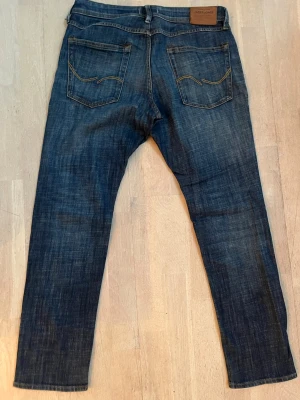 Jack & Jones Slim Glenn jeans blå 32/30 - Säljer ett par blå jeans från Jack & Jones, modell Glenn. Jeansen har klassisk femficksdesign och en slim passform. Storlek W32 L30. Fint skick!