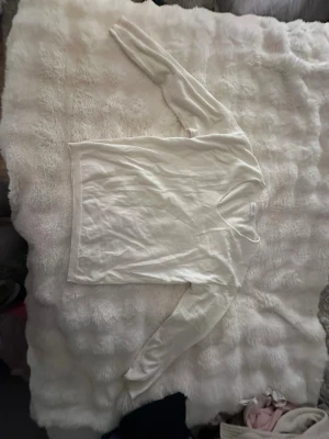 Vit långärmad tröja från Primark - En enkel och stilren vit långärmad tröja från Primark Cares i storlek XS. Tröjan har v-ringad hals och är gjord i mjuk bomull, perfekt för lager-på-lager under hösten och vintern. Passformen är normal och materialet känns skönt mot huden.