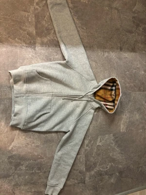 Burbery zip hoodie - Säljer denna riktigt snygga hoodiein. Ny pris=1800 mitt pris=650. Säljer den pga den är för liten och vill bara bli av med den så snabbt som möjligt 