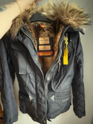 Svart Parajumpers parkajacka XS - Svart parkajacka från Parajumpers med fluffig päls runt huvan och mjukt pälsfoder inuti. 