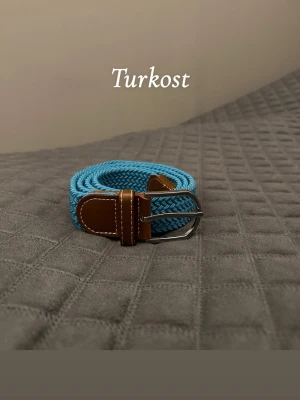 Turkost flätat bälte - Hej det är helt nytt från Bältgallerian. Det är 105cm långt och 3,5cm brett. Det är i ett elastiskt material så passar större storlekar också. Det finns flera färger bara gå in och kolla min profil.