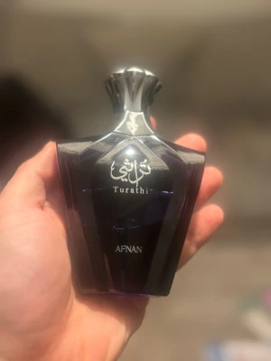 Afnan Turathi Blue - Snygg och modern parfymflaska från Afnan med namnet Turathi. Perfekt för dig som vill sticka ut med en unik design på din parfymhylla. Volym och ingredienser framgår ej på bilderna.