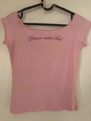 Rosa t-shirt Gina Tricot "Dansar vidare i livet”🫶🏻 - Söt rosa t-shirt från Gina Tricot med trycket "Dansar vidare i livet" i vinröd text över bröstet. T-shirten har korta ärmar och en något vid halsringning. Perfekt för dig som gillar statement-plagg och mjuka material. Super fin!🤍