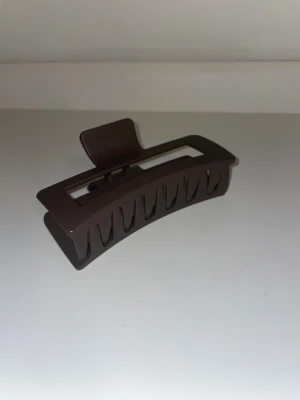 Brun hårklämma från Léonie - Säljer en stilren hårklämma från Léonie i matt brun färg. En klämma i XL som kan klara av tjockt hår och håller hela dagen. En enkel och trendig accessoar som passar till alla outfits✨😊