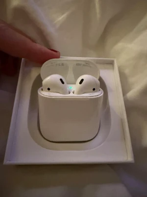 AirPods 2 - Apple AirPods 2 i original laddningsetui. Trådlösa hörlurar med bra batteritid och smidig anslutning till iPhone och andra Apple-enheter. .