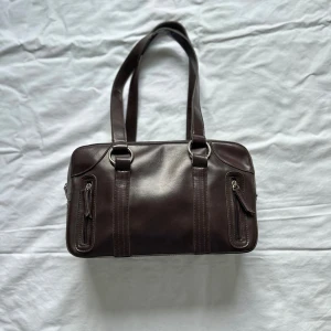 Brun väska  - Brun söt väska, mått 32x20cm. Vid köp av flera varor får du rabatt💛