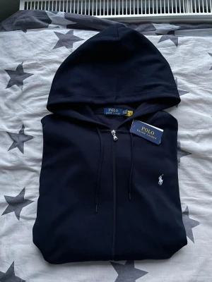 Polo Ralph Lauren kofta - Polo Ralph Lauren kofta med vit logga.  Fick den i present men den blev aldrig använd. Har endast legat hemma.  Skick: helt ny / oanvänd.