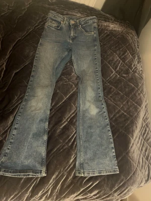 Blå low waist bootcut jeans  - Säljer ett par blåa low waist bootcut jeans i storlek 146. Jeansen har fickor både fram och bak. Jeansen är i väldigt gott skick men har tecken på användning så som blekare på lår och knän. Ordinare pris: 200kr. Pris kan diskuteras vis snabb affär. Frågor? Kontakta mig💕