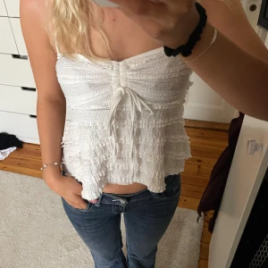 Vit topp - Supersöt vit linnetopp med tunna axelband och volangdetaljer. 