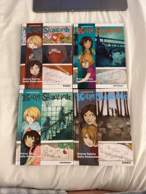 Kalle Skavank - Samling av spännande Kalle Skavank-böcker med färgstarka illustrationer och mysterier att lösa. Perfekt för unga deckarfans som gillar äventyr och kluriga gåtor. Titlar som 'Klotter i Kärrtorp', 'Skandalen vid Slussen', 'Lik på Städivik' och 'Änglar på Skogskyrkogården'. Alla för 150kr annars 45kr/bok