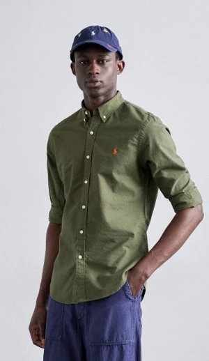 Olivgrön skjorta från Ralph Lauren - Olivgrön skjorta från Ralph Lauren i slim fit med klassisk button-down krage och orange broderad logga på bröstet. Skjortan har långa ärmar, vita knappar och är gjord i mjuk bomull. Perfekt för dig som gillar stilrena och tidlösa plagg.