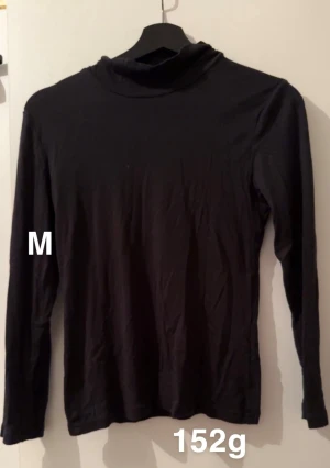 Svart polotröja, storlek M - Svart polotröja med lång ärm och enkel design. Perfekt för lager-på-lager och har en klassisk, smal passform. Snygg att matcha med jeans eller kjol för en clean look.🌸 Fint använt skick. Storlek m