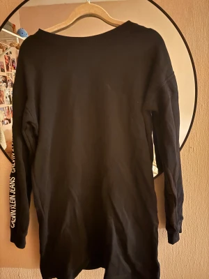 Svart Calvin Klein Jeans crewneck S - Svart crewneck från Calvin Klein Jeans i storlek S. Snyggt tryck med 'CALVIN KLEIN JEANS' längs armarna. Köpt i Australien och inte använt mycket alls. Pris kan diskuteras vid snabb affär. 