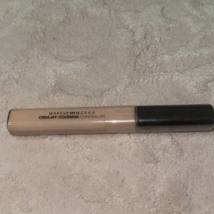 Makeup Mekka Creamy Covering Concealer - Creamy Covering Concealer från Makeup Mekka i färgen Light Neutral. Kommer i en smidig tub med svart lock och applikator. Perfekt för att täcka mörka ringar och ojämnheter. Lätt beige ton med neutral underton, passar dig som vill ha ett naturligt resultat.