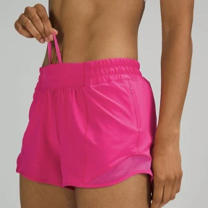 Rosa Hotty hot träningsshorts från Lululemon - Säljer ett par super snygga, rosa träningsshorts från Lululemon. De har hög midja med bred resår och snörning, samt diskreta fickor med dragkedja på sidorna. Perfekta för gymmet eller löprundan, tillverkade i ett mjukt och stretchigt material.