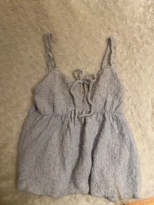 Topp - Supersöt ljusblå topp från Gina Tricot med spetsdetaljer på axelbanden. Toppen har knytning fram med ett hål under. På sista bilden ser man att jag har sytt nån cm eftersom att jag tyckte hålet var lite för stort. Syningen går att ta bort om man vill det💞
