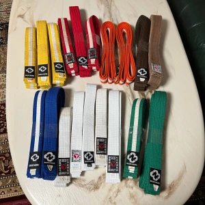 Färgglada budobälten från Budo Nord - Säljer ett gäng budobälten i olika färger från Budo Nord. Bältena finns i vitt, blått, grönt, brunt, rött, orange och gult, vissa med vita ränder. Perfekt för dig som tränar kampsport och vill ha flera alternativ. Klassisk design med broderade etiketter.