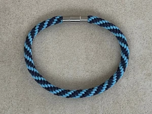 DIF Djurgården armband 19cm - Priset på armbandet är fast, knappen ”prisförslag” går inte att dölja.  Handflätat armband i mörkblått ljusblått med spänne i rostfritt stål, ca 19 cm. Det har en inflätad rostfri ståltråd som gör att det inte tänjer sig vid användning.  