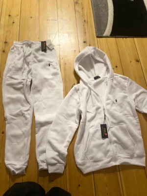 Vit hoodie från Polo Ralph Lauren S - Fräsch vit hoodie från Polo Ralph Lauren i storlek S. Klassisk zip-modell med huva och dragsko, broderad logga på bröstet och två stora fickor framtill. Mjuk och skön bomullsmix som är perfekt för chill dagar. Snygg och stilren design som alltid funkar.