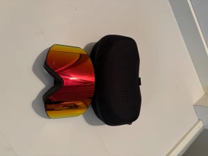 Montec skidglasögon med röd lins - Säljer ett par Montec skidglasögon med spegelröd lins och svart ram. Glasögonen har ett brett svart band med vit Montec-logga och kommer med ett hårt svart fodral. Perfekt för dig som vill ha cool stil i backen.