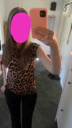 Leopardmönstrad topp med cap sleeve - Säljer en snygg leopardmönstrad topp med cap sleeve och rund hals. Toppens färger går i brunt, svart och beige och har en tight passform som framhäver siluetten. Perfekt för dig som vill sticka ut med ett djuriskt mönster.