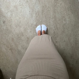 Beige ribbad långkjol - Säljer en beige långkjol med ribbad struktur och tight passform. Mycket fint skick!!