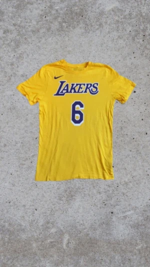 Nike LeBron tröja🐐 - Nike NBA-inspirerad T-shirt – gul med nr 6 och “James” på ryggen  Säljer en gul Nike-T-shirt i NBA-stil med tryck på ryggen. • Märke: Nike • Färg: Gul • Motiv: “James” + nummer 6 på ryggen • Storlek: small • Skick: Använd ca två gånger  • Passform: Regular fit • Perfekt för basketfans eller som snygg streetwear-tee  Hör av dig om du vill ha mått eller fler bilder! 🏀✨ 