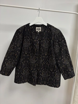  Twist & Tango jacka  - Unik jacka från Twist & Tango med metallicmönster i guld och silver. Jackan har rund hals, knappar framtill och ett detaljerat broderat mönster som ger en lyxig vibe. Perfekt för dig som vill sticka ut med en cool och elegant look. Helt ny med prislapp ord pris 1999kr