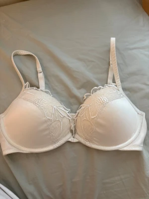 Vit bh från Intimissimi - Säljer en vit bh från Intimissimi med spetsdetaljer  broderade blommor på kuporna. 💕