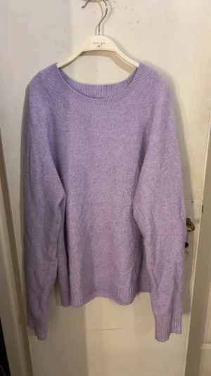 Ljuslila stickad tröja  - Supermysig ljuslila stickad tröja från VERO MODA med rund hals och ribbade muddar vid ärmslut och nederkant. Perfekt för att hålla sig varm och ändå se fräsch ut.