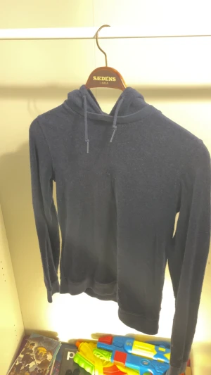 Mörkblå hoodie från Ralph Lauren - Snygg mörkblå hoodie från Ralph Lauren med mjukt frottéliknande material och klassisk huva med dragsko. På ryggen finns en stor vit patch med trycket 'P3' i blått och gult. Perfekt för dig som gillar streetwear och vill sticka ut.
