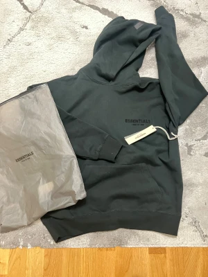 Svart Essentials Fear of God hoodie XS - Säljer denna feta Essentials hoodien i storlek XS kan passa också S, sitter väldigt bra på💯 riktigt fet inför sommaren/våren, passa på att köpa✨ Hoodien är i fint skick och säljs pågrund av att jag behöver pengar.🙌🏻 Hör gärna av dig vid frågor eller snabb affär💃