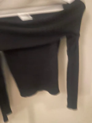 Svart offshoulder topp från H&M - Säljer en svart offshoulder topp från H&M i storlek XS. Toppen har långa ärmar och som sitter snyggt över axlarna. Perfekt för dig som gillar en stilren och enkel look. Skriv om du vill ha bättre bilder, vet att de inte är jätte bra💗💗