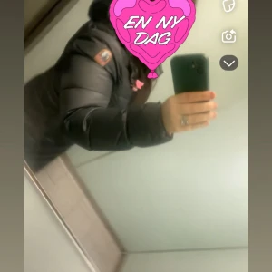 Svart lång dunjacka Parajumpers - Säljer en svart lång dunjacka från Parajumpers med huva och dragkedja hela vägen. Jackan är quiltad och har en klassisk patch på ärmen. Perfekt för kalla vinterdagar och riktigt snygg till streetwear-stilen.