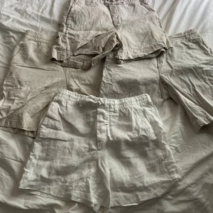 Beiga och vita linneshorts från Zara - Fyra par shorts i olika nyanser av beige och vitt från Zara och dressman, tillverkade i 100% linne. De har avslappnad passform, elastisk midja och vissa med knytband. Perfekta för varma dagar och en chill stil. 3 är Zara och 1 är Dressman.