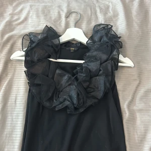 Svart ärmlös topp med volangkrage  - Säljer en svart ärmlös topp från CC i storlek M. Toppen ger en riktigt cool statement-look. Passar S-M ❤️