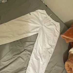 Lacoste byxor , vita , sport S - Vita mjukisbyxor från Lacoste Sport med relaxed fit och elastisk midja med snörning. Byxorna har det klassiska gröna krokodilmärket på benet och är gjorda i ett mjukt material som passar perfekt för att chilla eller träning.    Köpt från JDSports för 1150kr. Knappt använd, Bra skick 10/10. Passar bra till en vit Lacoste jacka eller en blå. Pris går att diskuteras.  Går bra att ses (STOCKHOLM)