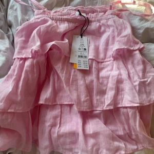 Rosa volang frill topp Gina Tricot  - Supersöt rosa topp från Gina Tricot. Skriv för bilder. Pris kan diskuteras. Köptes för 229kr säljs för 180kr för att den är helt ny. Andra bilden är från dels hemsida💗
