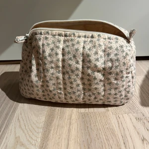 Blommig necessär. - 100% bomull. 21x25x10 cm.