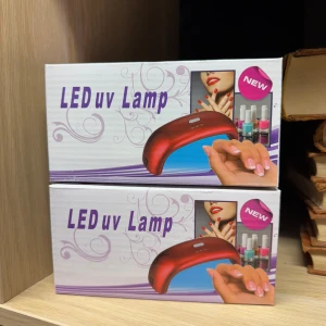 Två UV-lampor för naglar  - Säljer två UV-lampor i snygg röd färg, perfekt för att härda gel- och nagellack hemma. Lamporna har timerfunktion (10s, 30s, 60s) och passar till både manikyr och pedikyr. Kompakt design med måtten 160x65x50mm. Perfekt för dig som vill fixa naglarna själv. Helt nya 