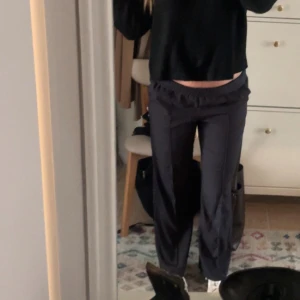 Svarta stilrena byxor med lösare passform  - Säljer ett par svarta byxor med bred resår i midjan och raka, vida ben. Jag är 172 cm lång och dom går över skorna på mig! Man kan vika ner resårbandet i midjan för att få dom mer low waisted. Storlek M men passar även S/L beroende på hur man vill att dom ska sitta!