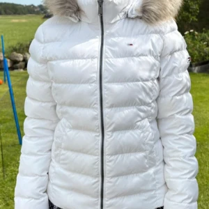 Vit pufferjacka från Tommy Jeans - Mycket fin formsydd dunjacka från Tommy hilfiger! Perfect nu till hösten-vintern. Knappt använd är som ny, varm och go inga fläckar eller märken +avtagbar luva. Ny pris 1900kr mitt pris 700 kan gå att diskutera❤️
